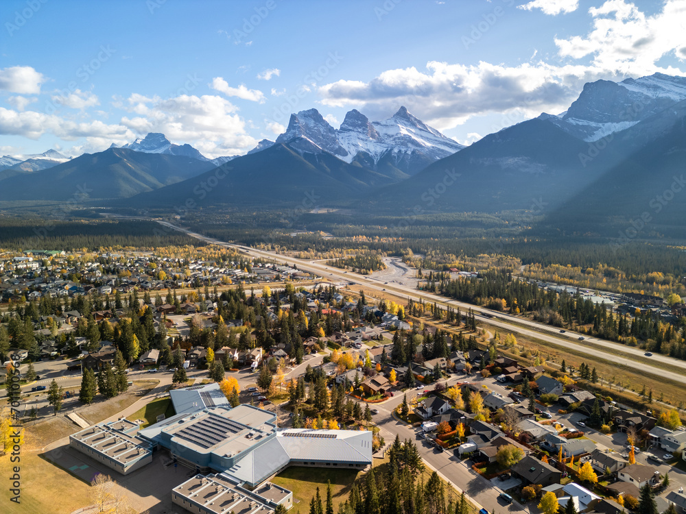 Canmore, Alberta, Canada. Aerial view of Trans-Canada Highway (Highway 1) in a autumn sunny day. The Three Sisters trio of peaks Canadian Rockies mountain range.