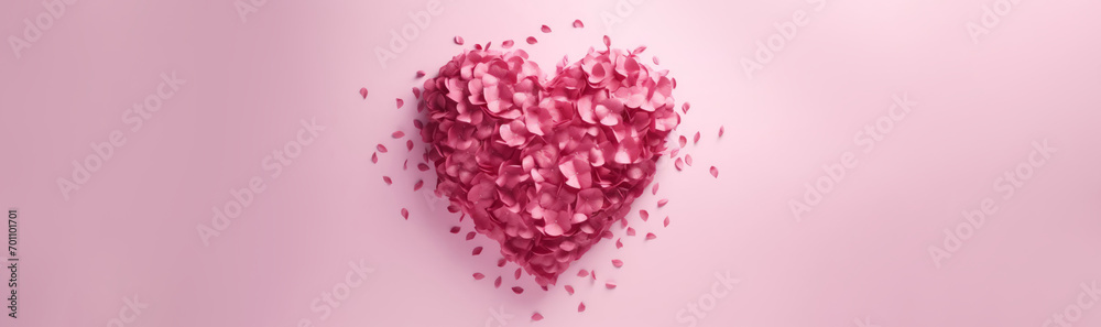 Heart made of flower petals on a pink background with space for text. Banner for Valentine's Day.