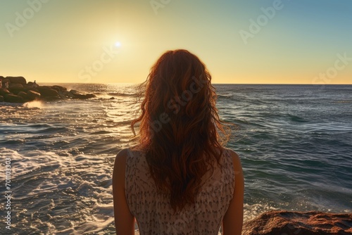 young girl on the background of the sea and sunset. © Ivy