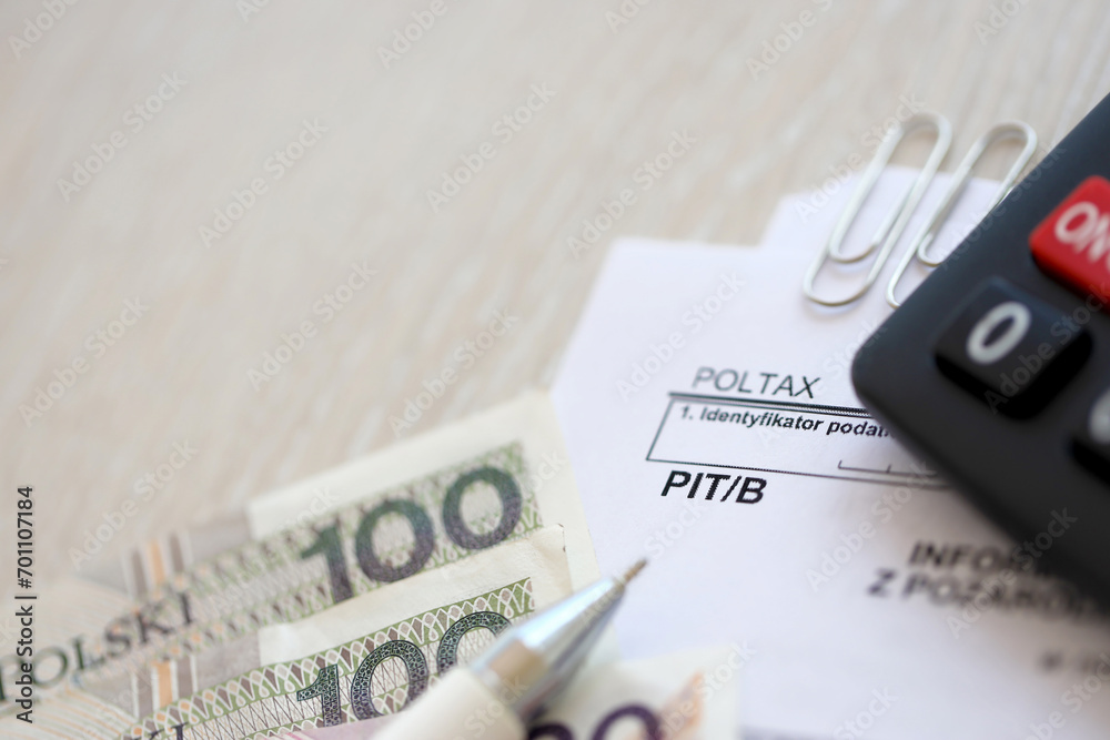 Information on amount of income or loss from non-agricultural economic activity, PIT-B form on accountant table with pen and polish zloty money bills close up Information on amount of income or loss from non-agricultural economic activity, PIT-B form on accountant table with pen and polish zloty money bills close up