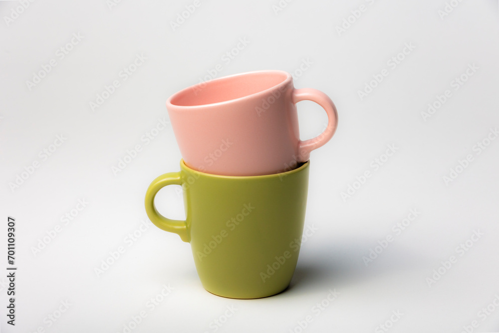 Mockup of a stack of two colorful coffee cups, green and pink, one inside the other, isolated on plain background Mockup of a stack of two colorful coffee cups, green and pink, one inside the other, isolated on plain background