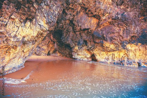 Rocky seascape in the evening. Cave Grote on the beach. Adraga beach, Portugal photo