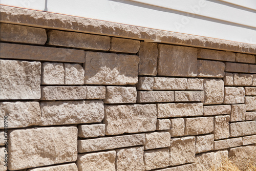 Natural stone veneer instal on the foundation of a home. Stone mason work.