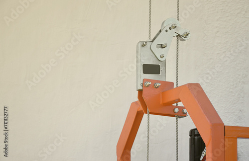 Safety lock as part of suspended wire rope platform for facade works on high multistorey buildings. Safety lock for securing the working platform from falling during control malfunction photo