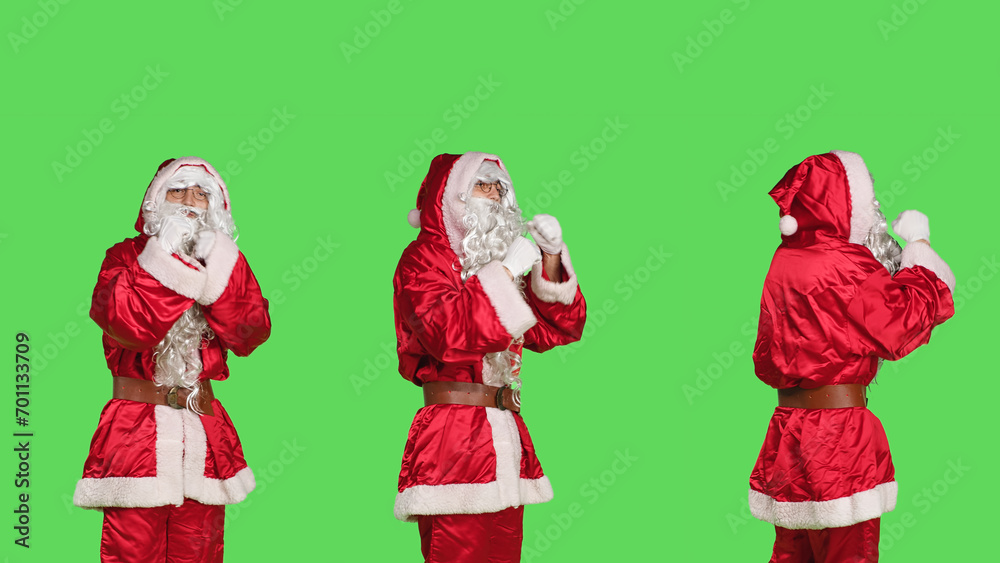 Violent saint nick throw punches in the air, acting aggressive with clenched fists. Strong santa claus character in costume ready for fight, confident person cosplay on greenscreen.