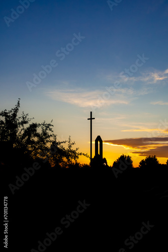 Christian Cross at sunrise with clouds and blue sky