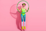 Photo of graceful sporty coach lady jumping doing gymnast exercise with hula hoop isolated over pastel color background