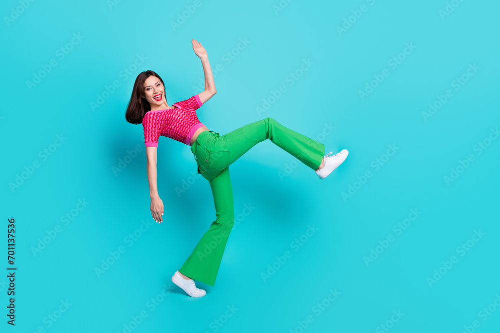 Naklejka premium Photo of pretty positive girl dancing nightclub doing huge step isolated over blue color background