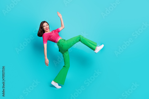 Fototapeta Naklejka Na Ścianę i Meble -  Photo of pretty positive girl dancing nightclub doing huge step isolated over blue color background