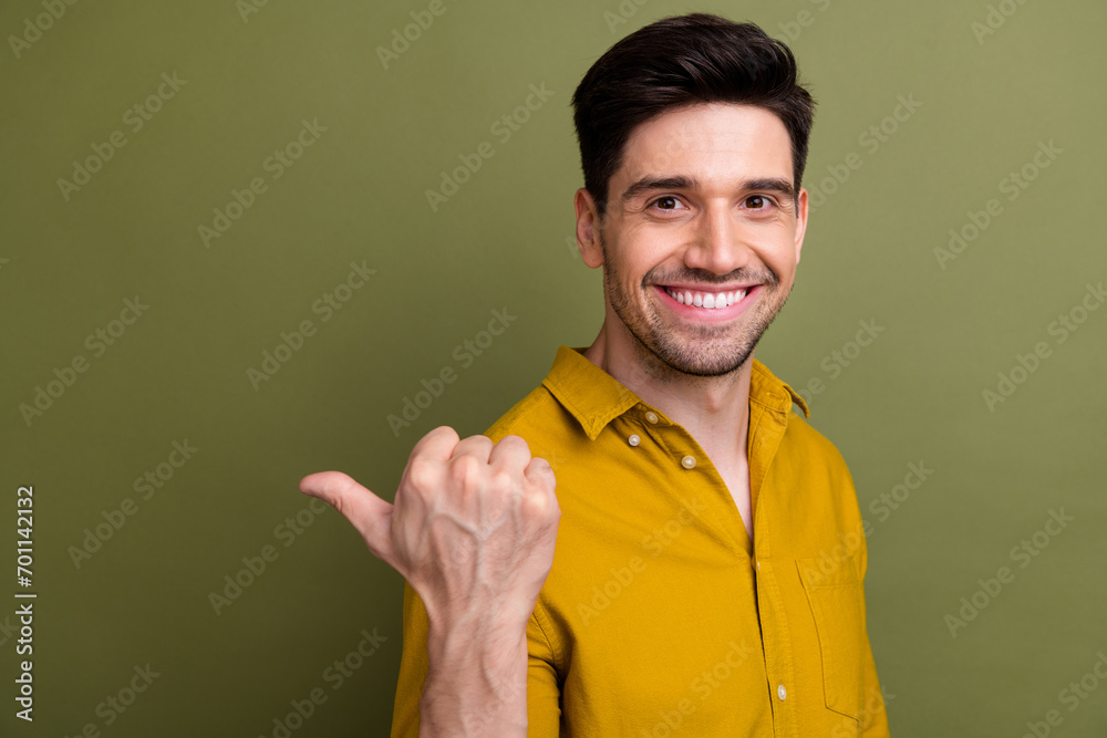 Profile photo of positive friendly person beaming smile direct thumb finger empty space isolated on khaki color background Profile photo of positive friendly person beaming smile direct thumb finger empty space isolated on khaki color background