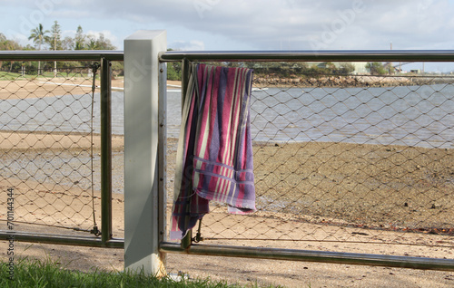 Foto Colorful towel hanging over a fence at a beach