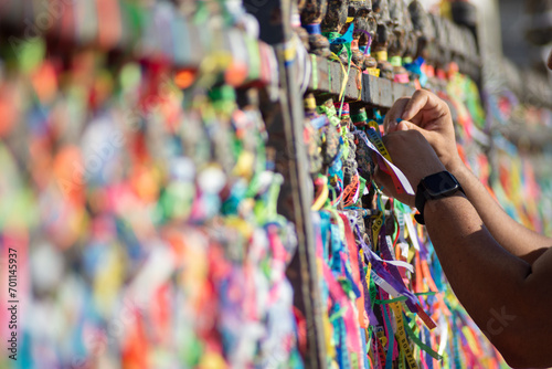 People are seen paying homage to Senhor do Bonfim by tying a souvenir ribbon on the church's iron railing. City of Salvador, Bahia. photo