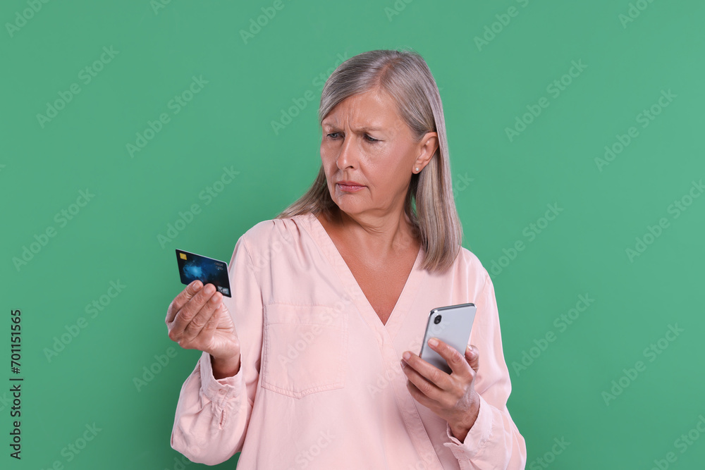 Worried woman with credit card and smartphone on green background. Be careful - fraud Worried woman with credit card and smartphone on green background. Be careful - fraud