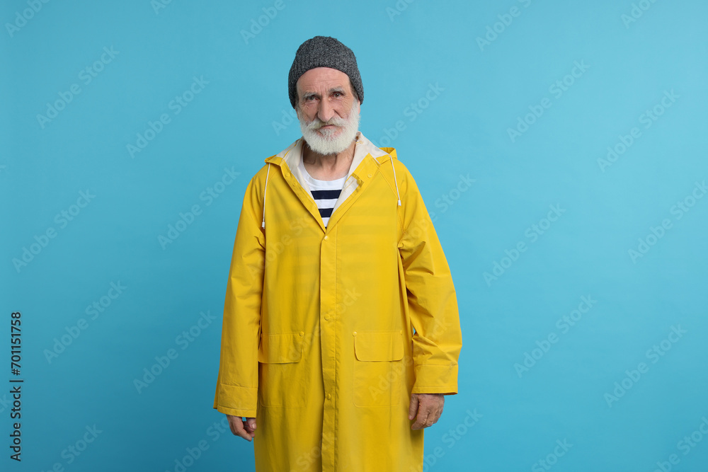 Fisherman in yellow raincoat on light blue background Fisherman in yellow raincoat on light blue background