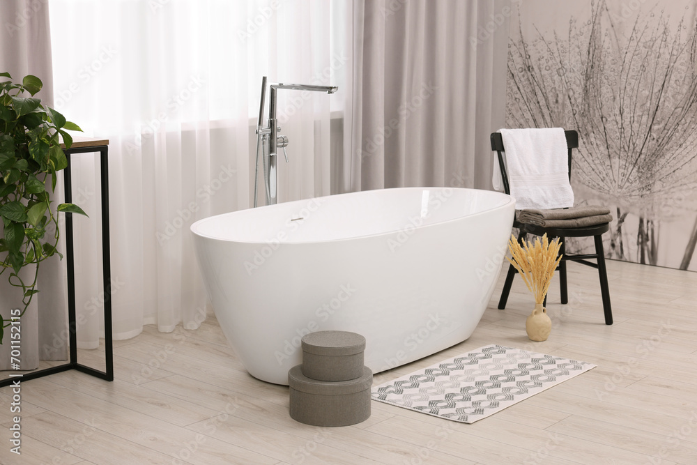 Stylish bathroom interior with soft bath mat and tub Stylish bathroom interior with soft bath mat and tub