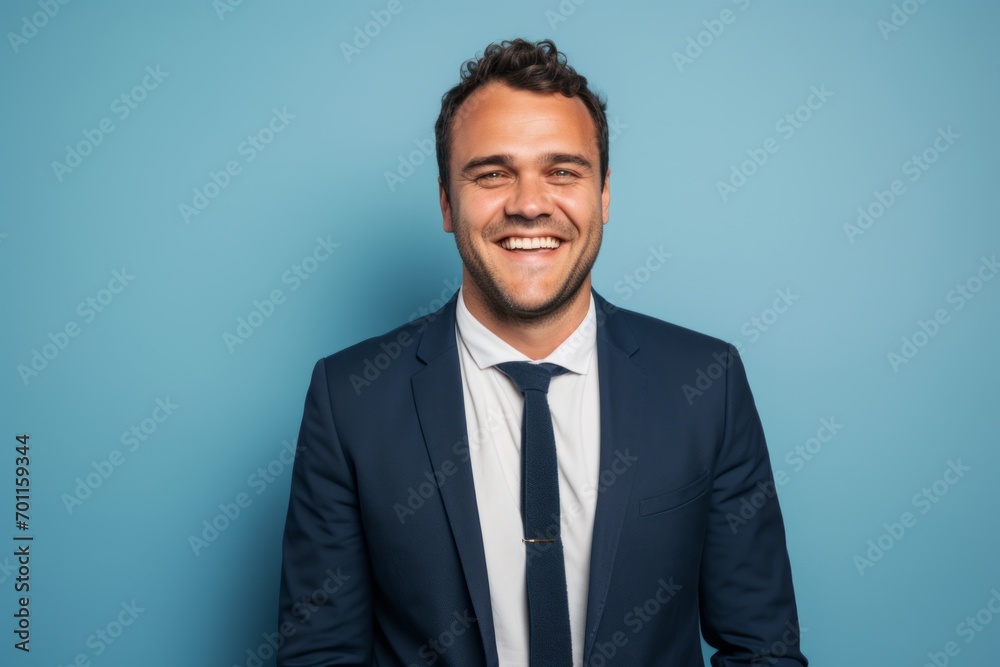 Portrait of happy young businessman in suit and tie on blue background Portrait of happy young businessman in suit and tie on blue background