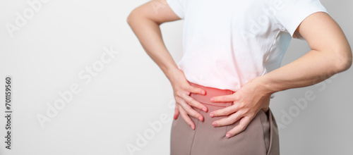 adult female with muscle pain on gray background. Elderly woman having back body ache due to Piriformis Syndrome, Low Back Pain and Spinal Compression. Office syndrome and medical concept photo