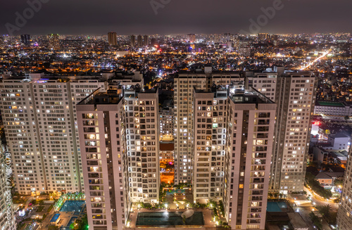 Aerial view of big city residential building and illuminated urban sprawl at night. © Paul