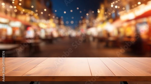 An empty wooden table overlooks a blurred background of festive lights, creating an inviting space for product display or dining.