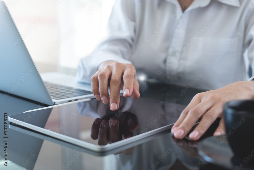 Businesswoman using digital tablet with laptop computer on office table, close up. Business woman surfing the internet, searching the information Businesswoman using digital tablet with laptop computer on office table, close up. Business woman surfing the internet, searching the information