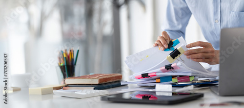 Businesswoman hands working in Stacks of paper files for searching and checking unfinished document achieves on folders papers at busy work desk office photo