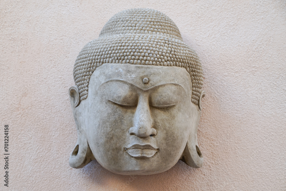Buddha head hanging on the wall as a symbol of relaxation and zen