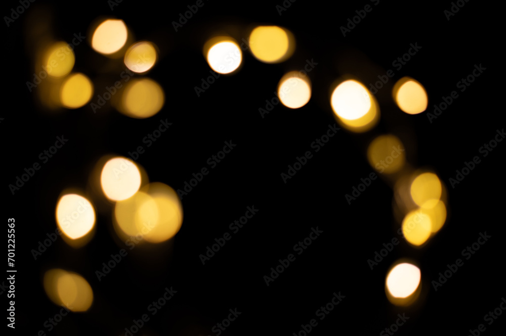 Golden blurred bokeh lights on black background. Christmas lights overlay.