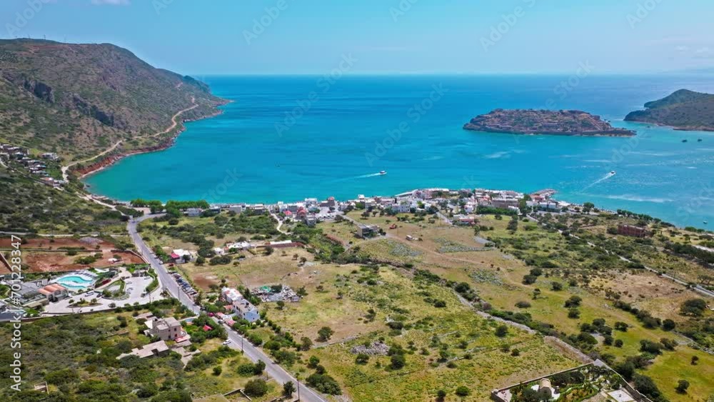 Scenic Aerial view of antique Fortress Island in Crete, Greece with tourists visiting. Spinalonga barren arid rocky islet in Elounda. Venetians built bastion-type seaward fortresses in Mediterranean Scenic Aerial view of antique Fortress Island in Crete, Greece with tourists visiting. Spinalonga barren arid rocky islet in Elounda. Venetians built bastion-type seaward fortresses in Mediterranean