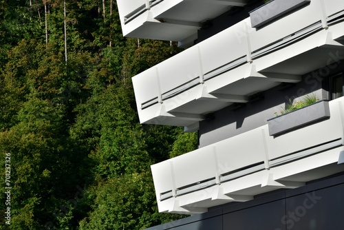Obraz na płótnie A view of the balconies of modern buildings situated near forest trees w salonie