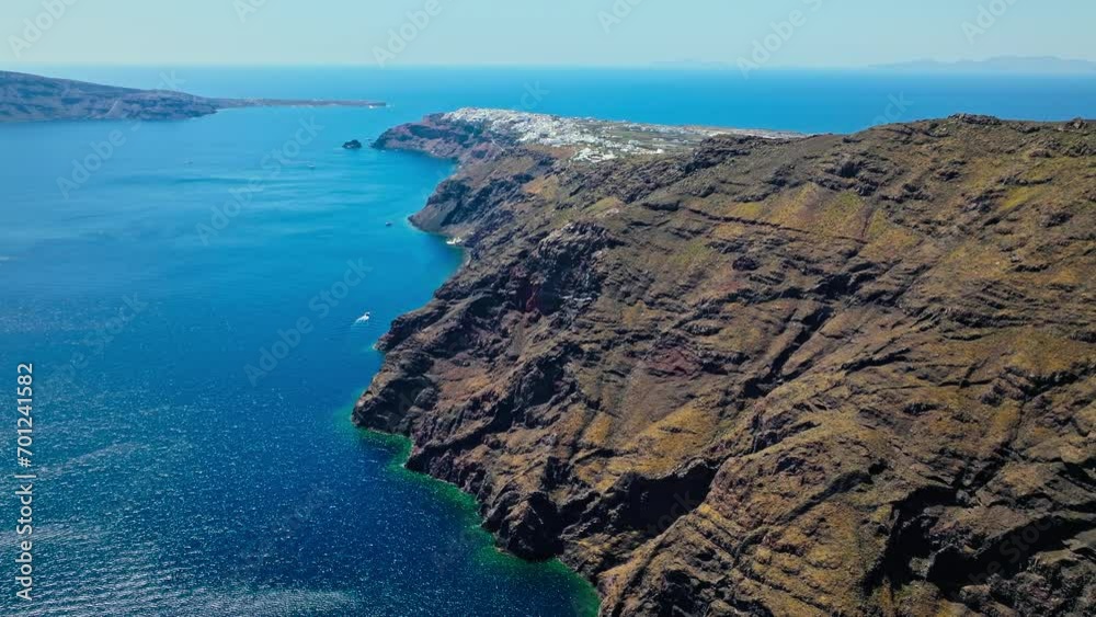 Aerial view of whitewashed Greek houses built on rocky cliffs in Santorini. Cyclades islands of Santorini with the intense blue colour of the sea in Santorini, Greece. Aerial view of whitewashed Greek houses built on rocky cliffs in Santorini. Cyclades islands of Santorini with the intense blue colour of the sea in Santorini, Greece.