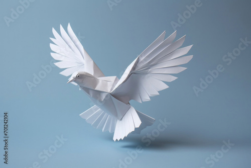 A white paper dove origami on a blank grey background.