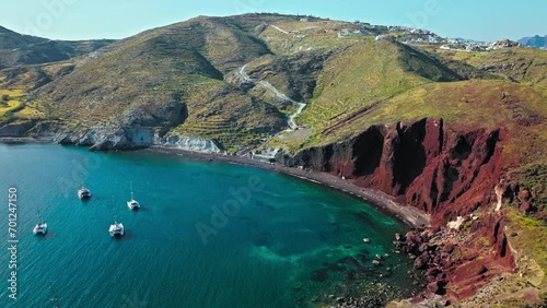 Aerial view of Red beach in Santorini surrounded by red hills and volcanic rocks. Rock formations with volcanic rocks, red pebbles, and sand of various colours, marine life for snorkelling lovers.