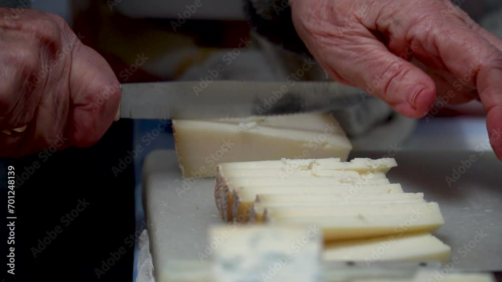 Closeup, person slicing cheese on the table.