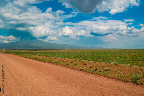 A dirt road against a mountain background at Ngorongoro Conservation Area in Tanzania photo