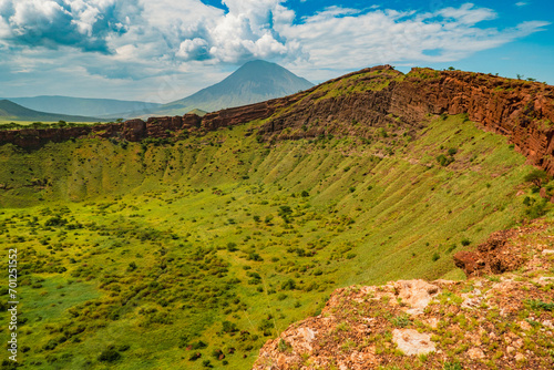 Scenic view of Shimo ya Mungu - The God's Pit with Mount Ol Doinyo Lengai in the background at the edge of Makonde Plateau in Tanzania photo