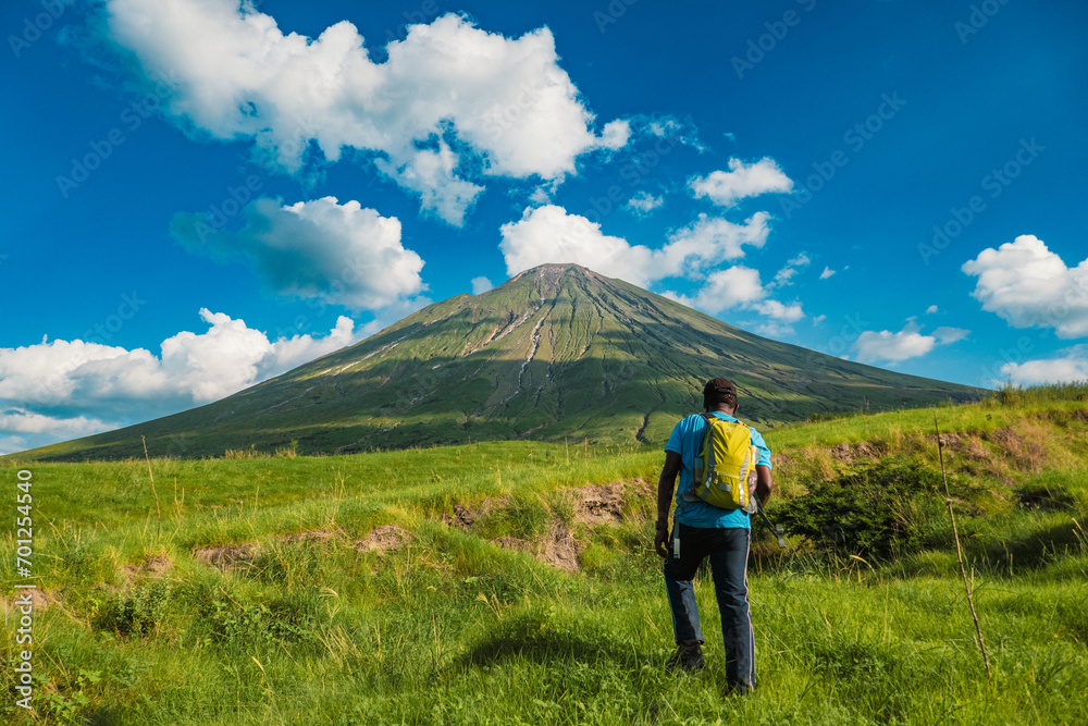 Rear view of a hiker with Mount Ol Doinyo Lengai in the background in Ngorongoro Area, Tanzania