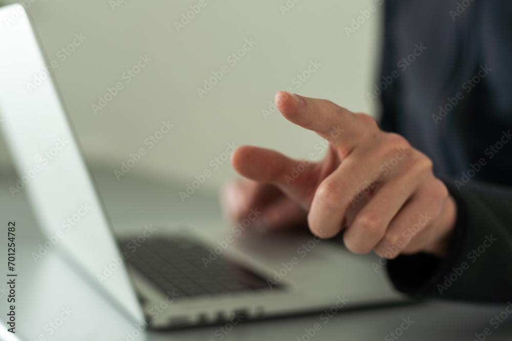 Finger pointing to laptop screen with important technology news. Businessman pressing virtual button on display. Finger pointing to laptop screen with important technology news. Businessman pressing virtual button on display.