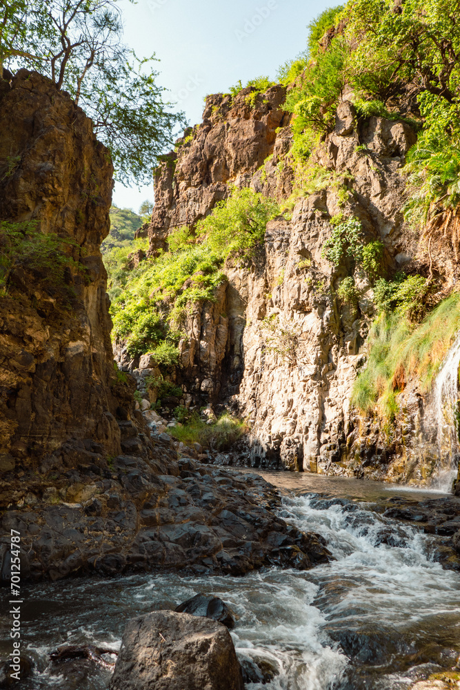 Obraz premium View of Ngare Sero river against rock formations at Ngorongoro Area, Tanzania