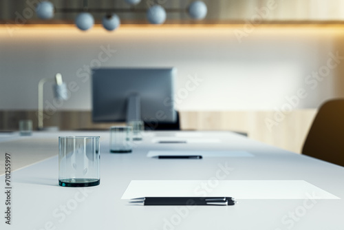 Close up of white table with objects in modern conference room. Blurry interior background. Workplace concept. 3D Rendering.