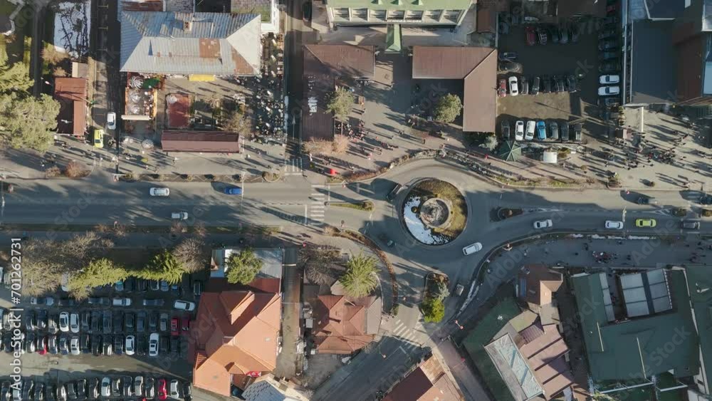 Aerial top down view of city street in motion. Drone view of cars and pedestrians in urban environment. 