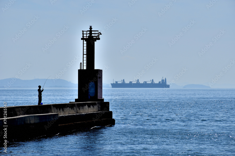 灯台のある風景、釣り人とタンカー。