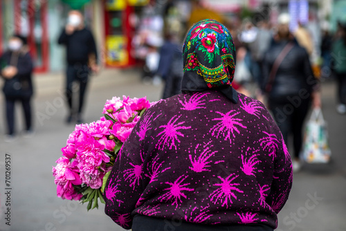 Woman carrying flowers in Chisinau central market, Moldova