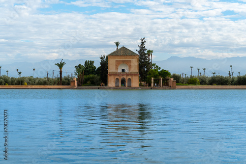 Photo of the Menara Gardens in the city of Marrakech. Photo of the lake with the house at the end of the lake. The house reflected in the lake. Cloudy day. photo