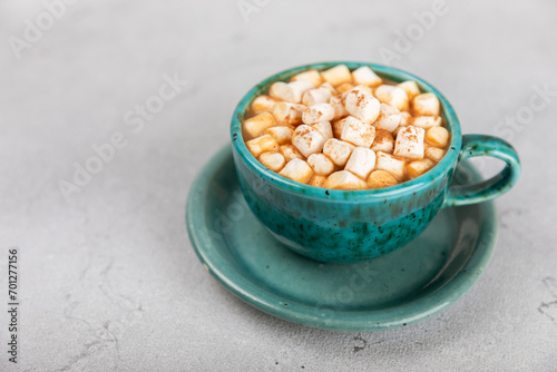 Hot drink with marshmallows and candy cane in cup on texture table.Cozy seasonal holidays.Hot cocoa with gingerbread Christmas cookies.Hot chocolate with marshmallow and spices.Copy space.