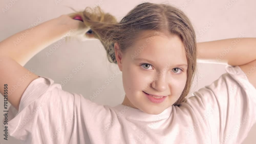 teenage girl with blond hair on a light background dries her hair, close up on the girls face. High quality FullHD footage teenage girl with blond hair on a light background dries her hair, close up on the girls face. High quality FullHD footage
