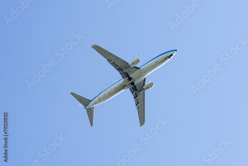 Twin engine passenger plane high in blue sky view from below