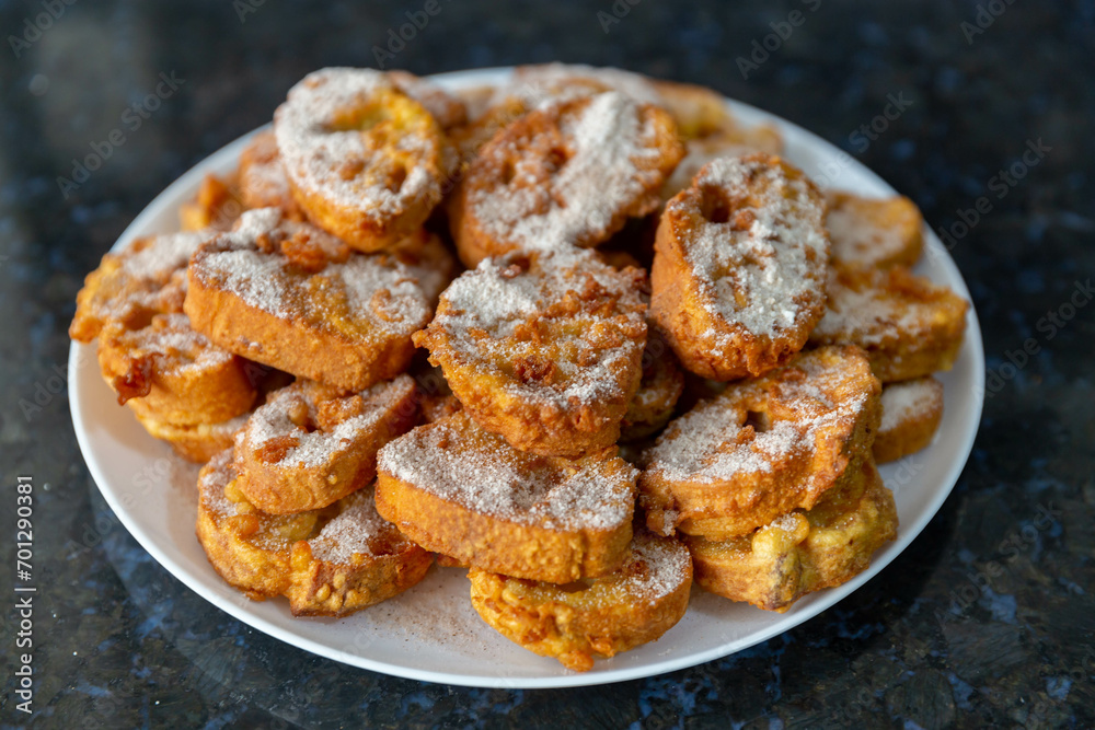 Typical Brazilian Christmas Rabanadas with egg yolk cream and cinnamon, Spanish Torrijas on golden plate on a Christmas dinner table. Fine details Typical Brazilian Christmas Rabanadas with egg yolk cream and cinnamon, Spanish Torrijas on golden plate on a Christmas dinner table. Fine details