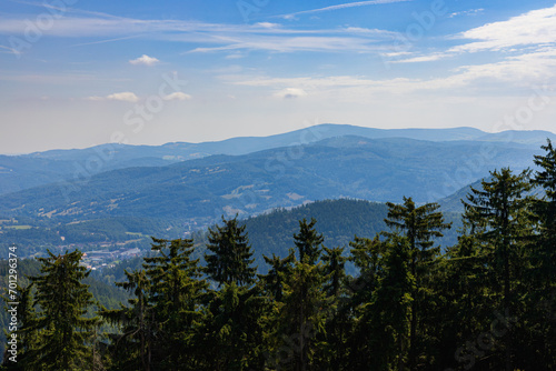 Fototapeta Naklejka Na Ścianę i Meble -  Beautiful green and blue panorama of layers of mountains and trees and some fields seen from top of viewing tower at highest mountain in this area