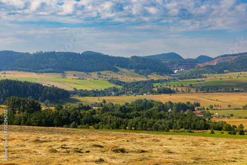 Fototapeta Naklejka Na Ścianę i Meble -  Beautiful landscape of glades and clearing full of fields and trees between it at mountains at sunny cloudy day