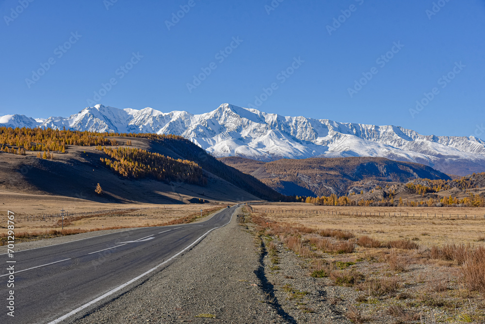 Mountain landscape. Road leading to mountain peaks in autumn.